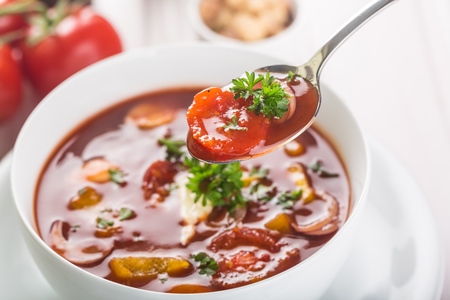 roasted tomato soup with beans, celery and sweet pepper garnished with fresh parsley closeupの写真素材