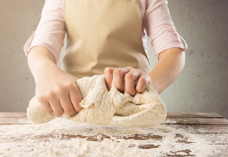 Chef hands cooking dough on dark background