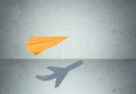 Paper plane in mid flight with shadowの写真素材