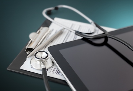 Digital tablet with stethoscope and paperwork