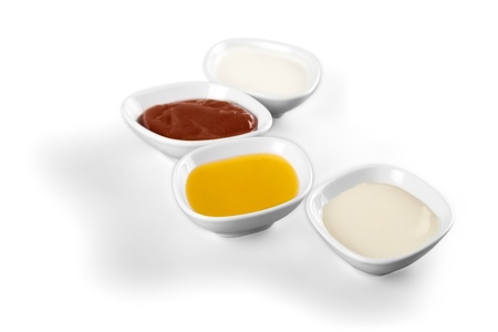 the various barbecue sauces in ceramic bowlsの写真素材