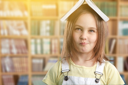 Little girl is happy with book at te libraryの写真素材