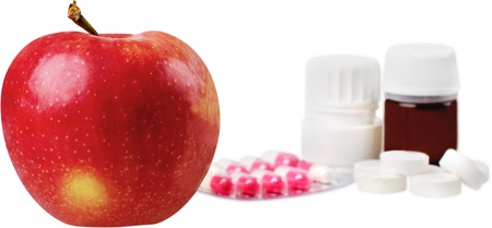 Close-up of fresh red apple with drugs isolated on white backgroundの写真素材