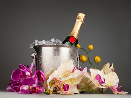 Champagne bottle in an ice bucket with floral arrangementの写真素材