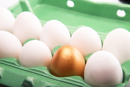 Golden Egg With White Eggs In Egg Box Close-up