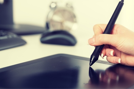 Hand of the designer with a penの写真素材