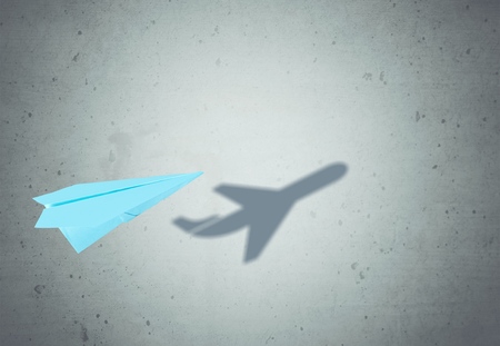 Paper plane in mid flight with shadowの写真素材