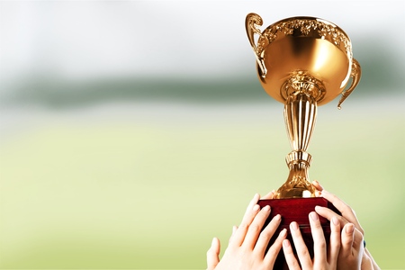 Hands holding golden trophy on a white background