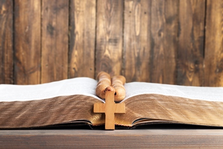 Rosary beads resting on open bible onの写真素材