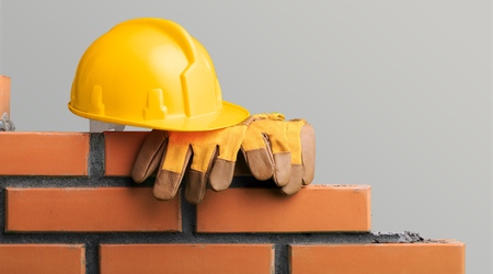 Yellow helmet with equipment on construction background