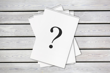 Question mark paper heap on wooden tableの写真素材