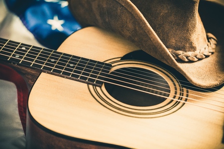 Acoustic Guitar and Cowboy Hat with American Flag on Backgroundの写真素材