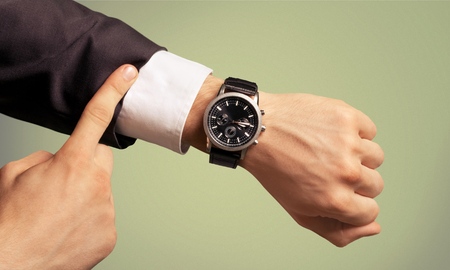 Businessman pointing at hand watch on whiteの写真素材
