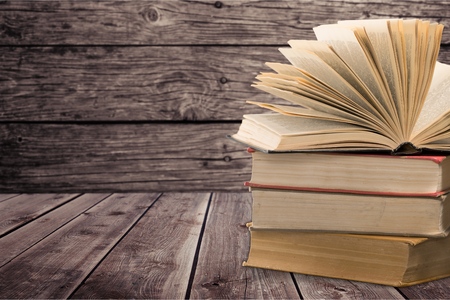A hand holding books with words