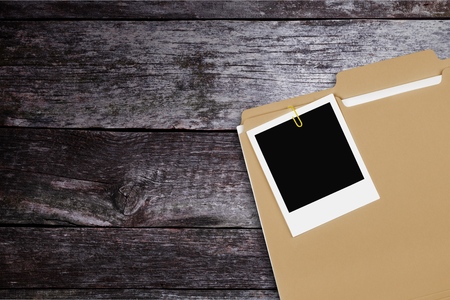 Stacked yellow file folders on wooden backgroundの写真素材