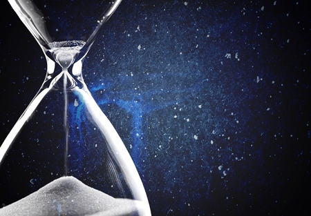 Sand running through the bulbs of an hourglass