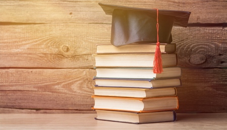 Graduation hat and stacks of books, close-up viewの写真素材