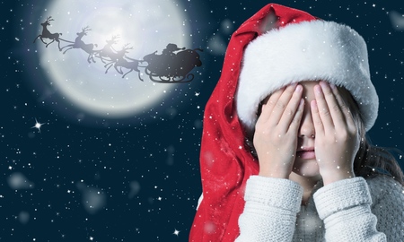 Little girl in santa hat isolated on night backgroundの写真素材
