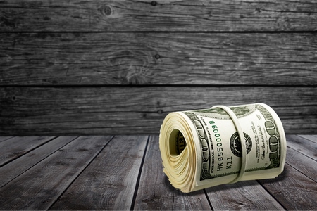 Dollar roll tightened with band. Rolled money isolated on white