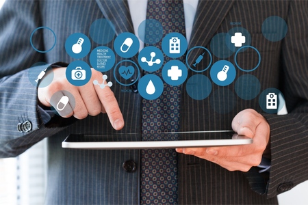 Man with tablet with holding medical signsの写真素材