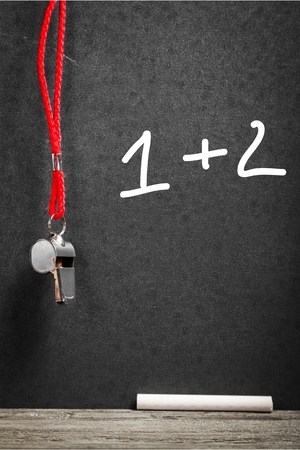 A coach whistle hanging from a blackboardの写真素材