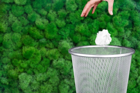 Hand throwing out paper into trash basketの写真素材