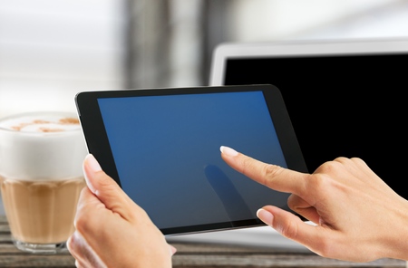 Woman holding a tablet computer in a cafe