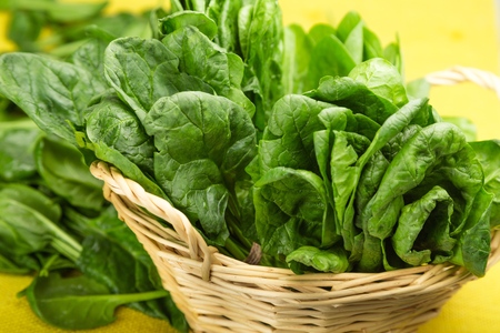 Young Spinach Leaves In Basket And More On Yellow Tablecloth Close-upの写真素材