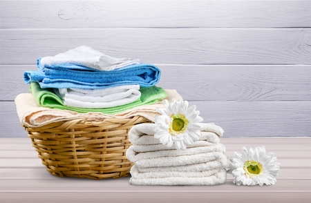 Laundry Basket with colorful towels on backgroundの写真素材