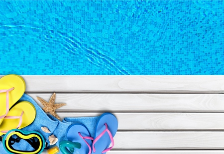 Swimming time ,flip flops and towel by the pool