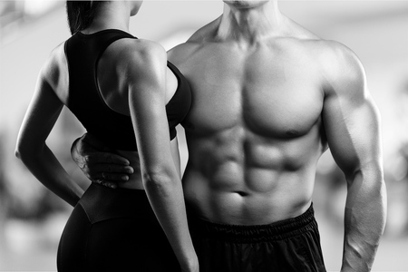 Young sporty couple posing on black background.の写真素材