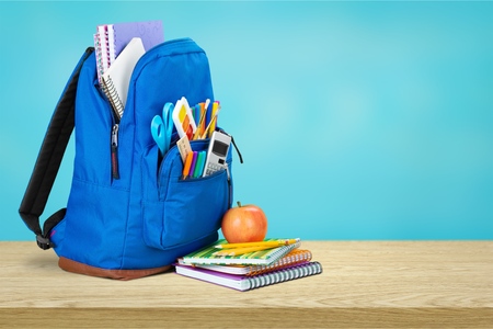 Colorful school supplies in backpack on blackboardの写真素材