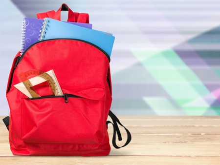 Colorful school supplies in backpack on blackboardの写真素材