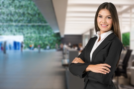 Young businesswoman in suit on blurred office