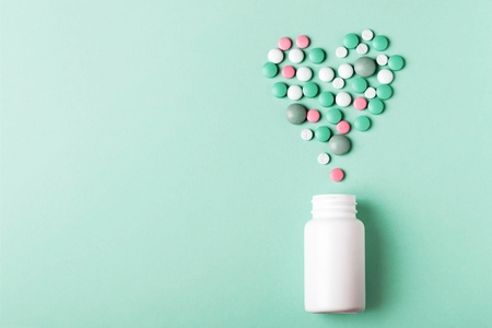 Heart sign make of pills on redの写真素材
