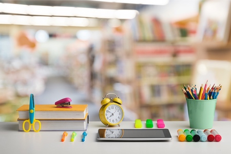 Back to school concept with school books, textbooks, backpack and stationery supplies on classroom...