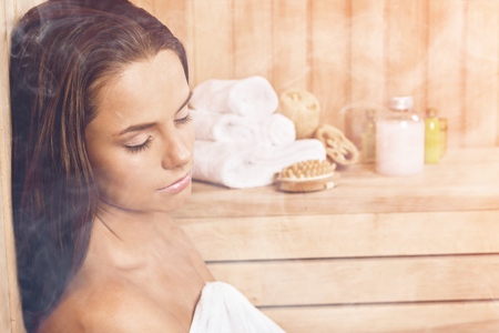 Young beautiful relaxed woman in saunaの写真素材