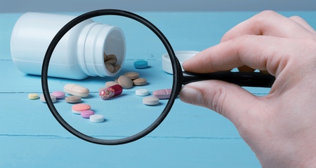 Pharmacist or expert on pharmaceutical inspection identifies pills. Testing, verification and determining pharmaceutical counterfeiting or fakes of medicines and medicinal substance quality concept
    
    - Imageの写真素材