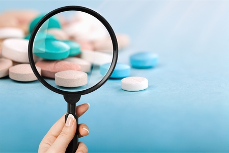 Pharmacist or expert on pharmaceutical inspection identifies pills. Testing, verification and determining pharmaceutical counterfeiting or fakes of medicines and medicinal substance quality concept
    
    - Imageの写真素材