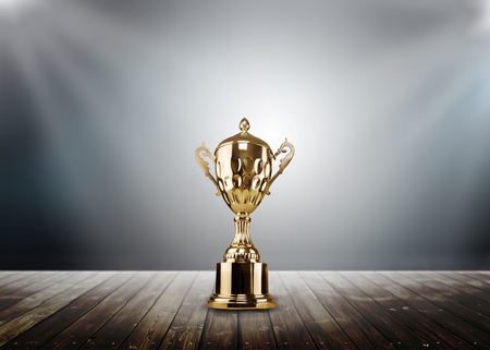 Champion golden trophy placed on wooden tableの写真素材
