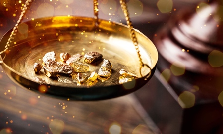Small gold nuggets in an antique measuringの写真素材