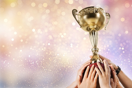 Hands holding a champion golden trophy on white background