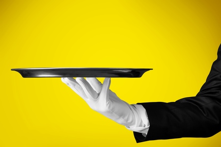 Elegant waiter hand in white glove holding an empty plateの写真素材