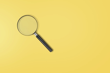 Magnifying glass on yellow background. Top view. Flat lay. Copy space. Conceptの写真素材
