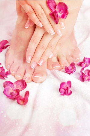 Perfect hands on female feet isolated on white background