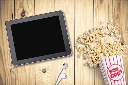 Table with popcorn bottle and logo and earphone. is a global provider of streaming movies and TV series.の写真素材