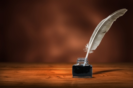 Quill pen with inkwell on deskの写真素材