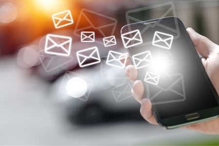 Woman hand using smartphone to send and recieve email for business on bokeh vintage color tone background.の写真素材