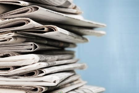 Pile of newspapers on white backgroundの写真素材