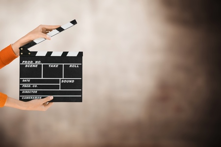 Women hands holding clapper board for making video cinema in studio.Movie production clapper board or slate film concept.の写真素材